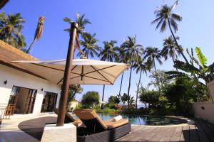 Kubutambahan肯巴厘别墅酒店 的游泳池旁的遮阳伞和椅子