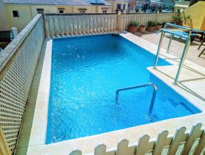 托雷德尔马尔Viña Home的一座带金属围栏和蓝色水的游泳池