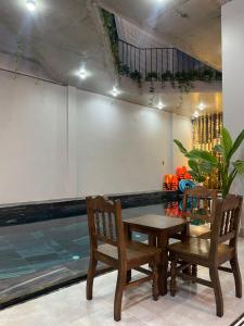 峰牙Celia Boutique Hotel的游泳池旁的带桌椅的用餐室
