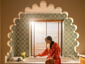 麦纳麦索菲特巴林匝拉塔拉萨海水疗酒店的坐在浴室镜子前的女人