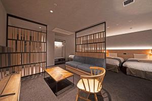 高山hotel around TAKAYAMA, Ascend Hotel Collection的酒店客房设有一张沙发和一张床