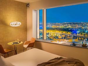 巴黎Too Hotel Paris - MGallery的卧室设有窗户,享有城市美景