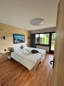 南达2,5 pièces à Haute-Nendaz, grande terrasse, piscine, sauna, tennis的铺有木地板的客房内设有一间卧室和一张床。