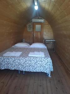 弗切瓦拉诺Torre del Lago的木制客房内的一间卧室,配有一张床
