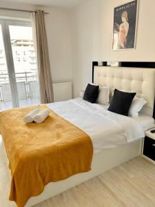布拉索夫JAD - Comfortable - Apartments - Coresi的卧室设有一张大白色的床和大窗户