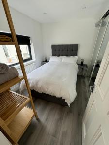 卢坎Weston Studio的一间卧室配有一张带白色床单和梯子的床。