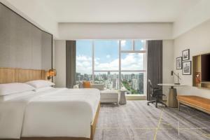 广州Sheraton Guangzhou Hotel的酒店客房设有一张床和一个大窗户