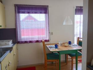 KongsfjordKongsfjord Holiday Home的厨房配有桌椅和窗户。