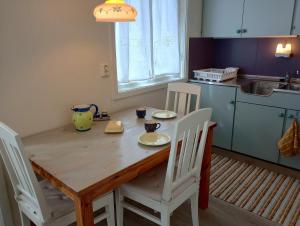 KongsfjordKongsfjord Holiday Home的厨房配有木桌和白色椅子