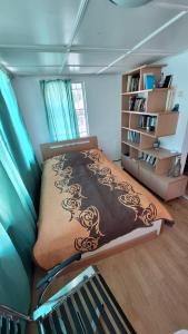 尤尔马拉隆达公寓的一间卧室设有一张床和一个书架