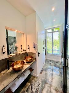 勒鲁雷恩阿皮涅城堡酒店的浴室设有2个水槽和2面镜子