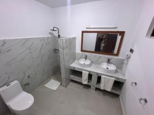 南威Nungwi Beach Front Ex Sunrise Beach Nungwi的浴室设有卫生间、2个盥洗盆和镜子