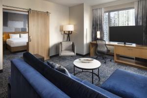 洛杉矶洛杉矶活力洛城万怡酒店的酒店客房设有沙发、电视和床。