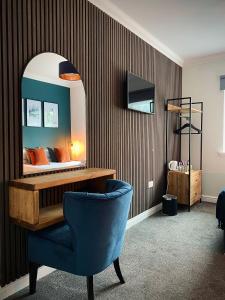 阿罗柴尔洛赫赛德宾馆的一间卧室配有一张带镜子和蓝椅的床