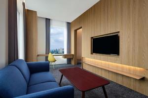 雅加达Aloft South Jakarta的酒店客房设有蓝色的沙发和电视。