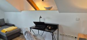 马里博尔Apartment Dolce Vita Maribor的客房设有带笔记本电脑和沙发的桌子。