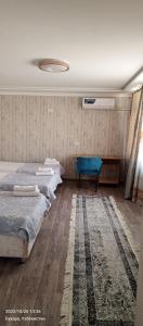 布哈拉Hotel Guest House GOLDEN DEGREZ的一间带两张床的卧室和地毯