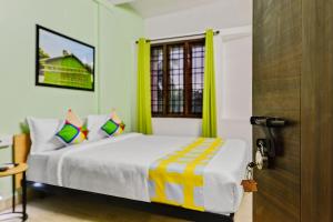 钦奈OYO Home G-cloud Near Thirumangalam Metro Station的一间卧室配有一张黄色窗帘和门的床