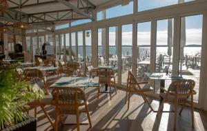 圣特罗让莱班塔拉萨欧勒龙岛诺富特酒店的餐厅设有桌椅和窗户。
