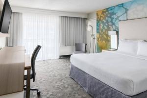 奥兰多Courtyard by Marriott Orlando Lake Buena Vista at Vista Centre的酒店客房设有一张大床和一张书桌。