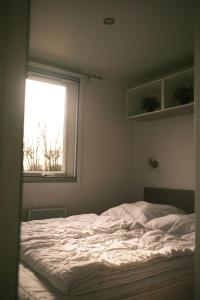 费马恩Campingplatz Johannisberg的卧室内的一张未铺好的床,设有窗户