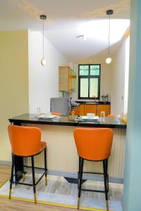 亚的斯亚贝巴Messay Hotel的厨房配有橙色椅子和黑色柜台