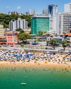 萨尔瓦多Rede Andrade Barra的海滩上有遮阳伞和水中的人
