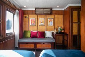 下龙湾传奇下龙私人邮轮酒店 - 哈亚巡游管理局的配有红色和绿色枕头的长凳