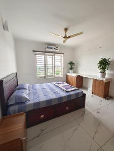 特里凡得琅Luxurious Apartment with a pool and gym near Trivandrum railway station的一间卧室配有一张床和吊扇