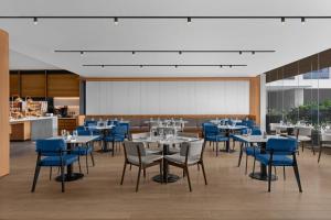 宿务Fairfield by Marriott Cebu Mandaue City的一间配备有桌子和蓝色椅子的用餐室