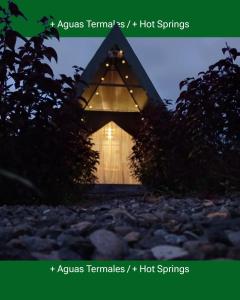 福尔图纳Flora Glamping de Abuela的一座带灯的三角形屋顶的小房子