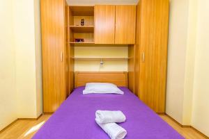 拉茨斯切Apartment Leo的一间小卧室,配有一张带两条毛巾的紫色床