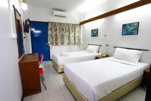 清迈Chomdoi House Hotel SHA Extra Plus的酒店客房设有两张床和电视。