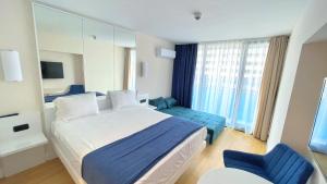 巴统Apartments Black Sea Resort Luxe的配有一张大床和镜子的酒店客房