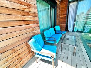 马马亚Blue Bike Seaview Apartment & Penthouse的木甲板上配有两把椅子和一张桌子
