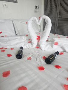 桑当The Wight Bay Hotel - Isle of Wight的一张红心床和两瓶葡萄酒及毛巾