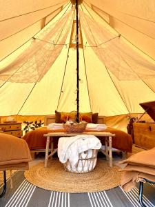 尼堡BohoFyn的一间设有一张桌子和一个篮子的帐篷的房间