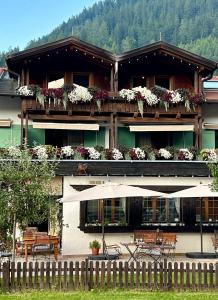 埃尔瓦尔德Das Halali - dein kleines Hotel an der Zugspitze的一座带鲜花和桌椅的阳台的建筑