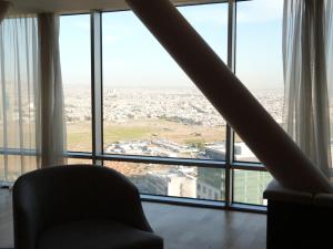 埃尔比勒Radisson Hotel & Residences Erbil的配有大窗户的客房内的椅子