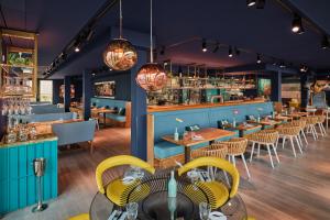 诺德奈New Wave的餐厅拥有蓝色的墙壁和黄色的椅子和桌子