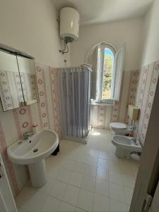 法维尼亚纳Dimora A' Muciara的一间带两个盥洗盆、淋浴和两个卫生间的浴室