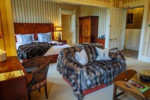 阿克菲尔德Horsted Place Hotel的酒店客房配有一张床、一张沙发和一张床。