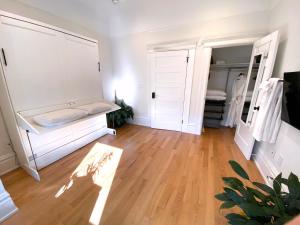 旧金山4br2ba Remodeled Home In The Heart Of The Castro!的一间设有白色橱柜和硬木地板的客房