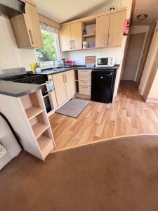 阿伯里斯特威斯Van number 123 Beautiful Caravan sleeps 4 to 6的厨房配有木制橱柜和黑色冰箱。