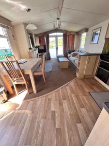 阿伯里斯特威斯Van number 123 Beautiful Caravan sleeps 4 to 6的厨房以及带桌椅的起居室。