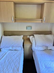 阿伯里斯特威斯Van number 123 Beautiful Caravan sleeps 4 to 6的卧室内两张并排的床