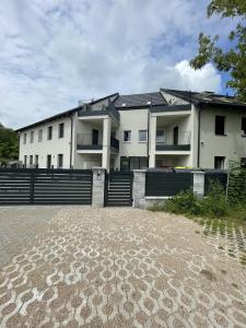 LangenzersdorfLangenzersdorf Apartment的前面有栅栏的大白色建筑