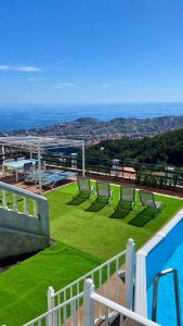 丰沙尔Studio Geek Villa - Matrix Open Space - all year round Pool, Dining Pergola, Barbecue - Funchal Holiday Home by Salviati Stays的一个带草坪椅和游泳池的阳台