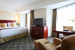 成田International Resort Hotel Yurakujo的酒店客房设有一张大床和一台电视。
