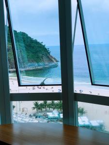 里约热内卢suite deluxe vista mar Copacabana - entrada independente的客房享有海滩和大海的景致。